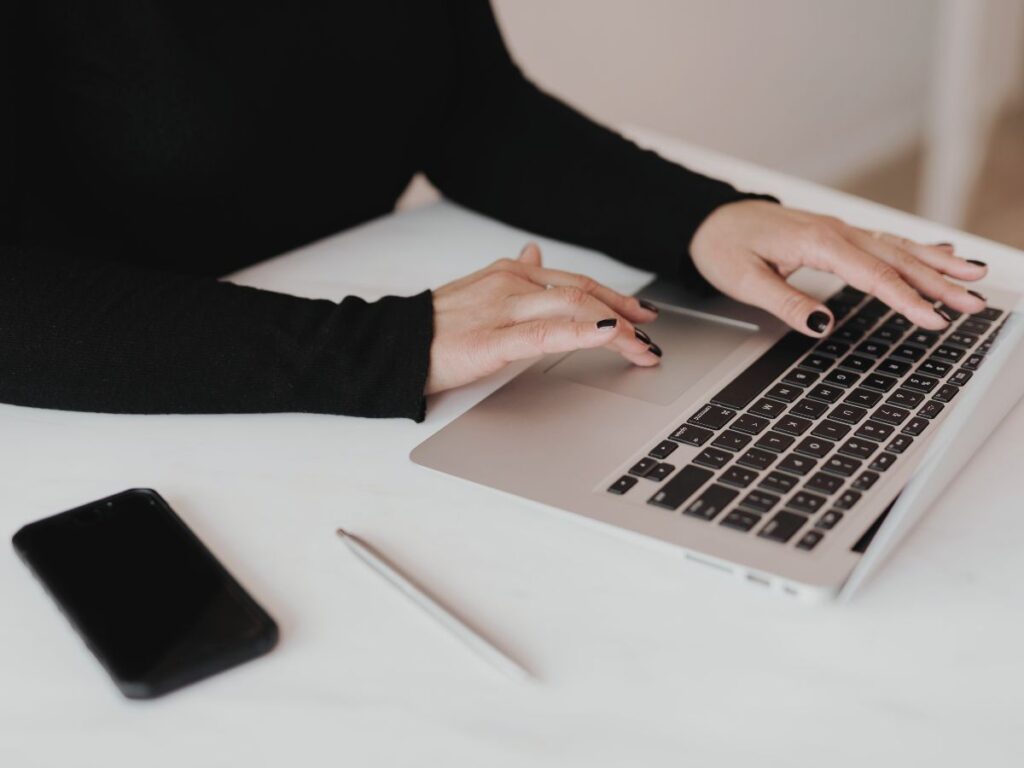 a woman typing at a laptop